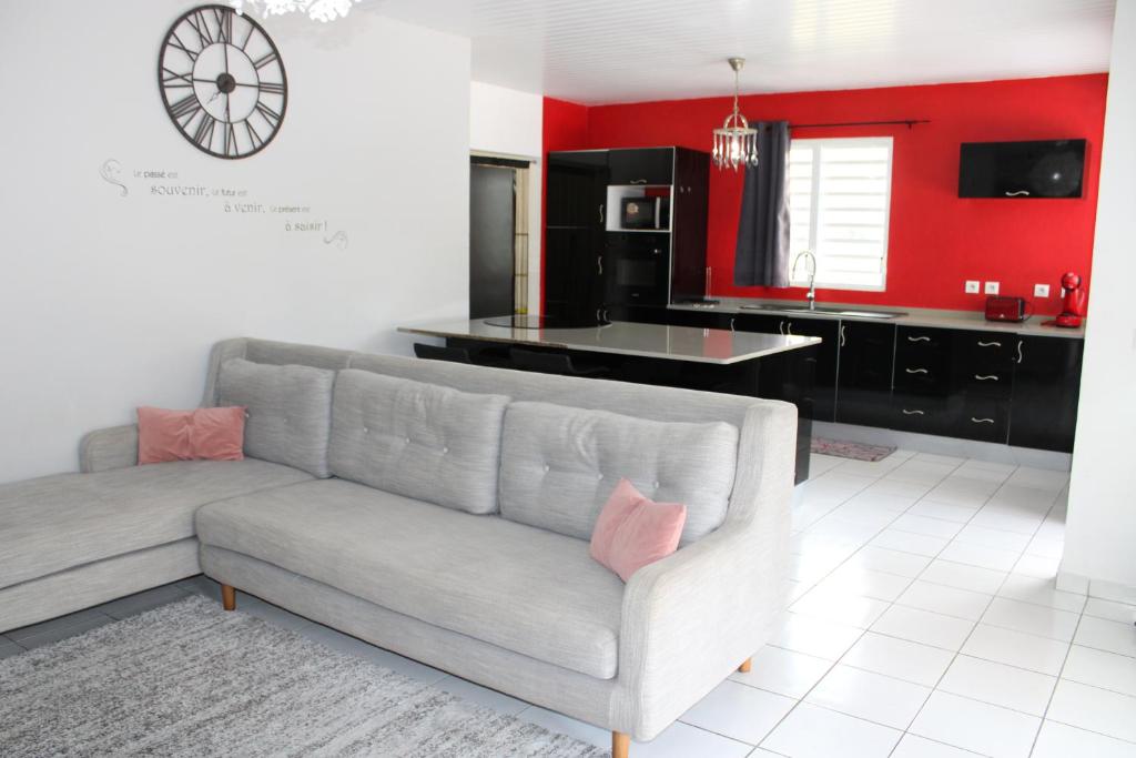 a living room with a couch and a kitchen at Villa Rubis - proche aéroport in Matoury