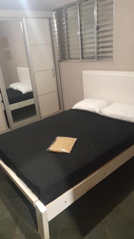 - un grand lit dans une chambre avec un miroir dans l'établissement Casa no centro, à Pirapora do Bom Jesus