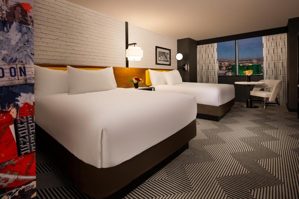 a hotel room with two beds and a desk at Pleasant Unit at New York New York Strip Las Vegas in Las Vegas