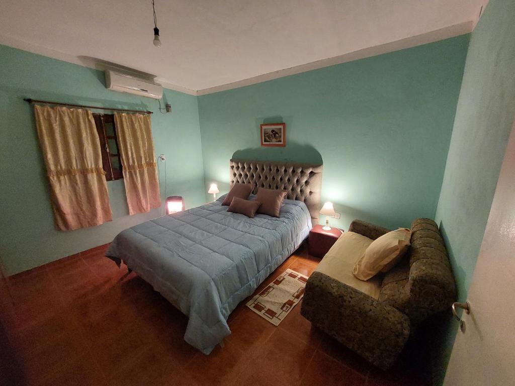 um quarto com uma cama e um sofá em Barrio Residencial San Martín - La Chacarita em San Fernando del Valle de Catamarca