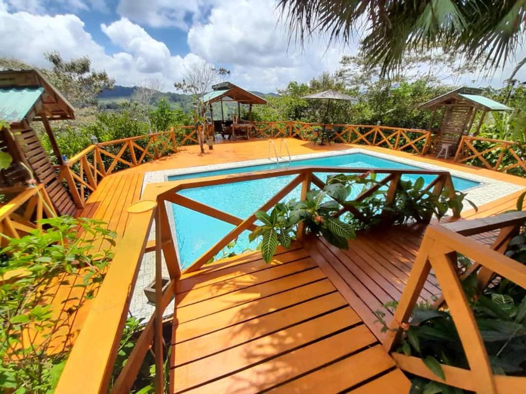 a wooden deck with a swimming pool on a house at Corredores del Pacuare in La Suiza