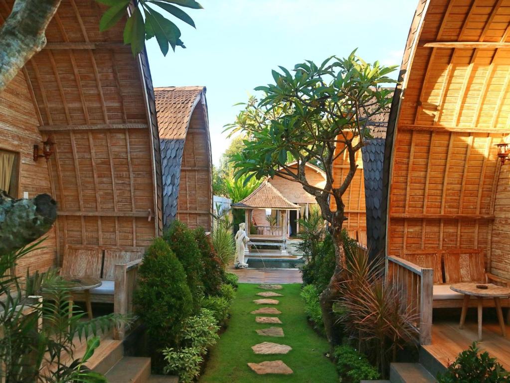 a garden with a pathway between two buildings at Wana Shanti Villa in Bringkit