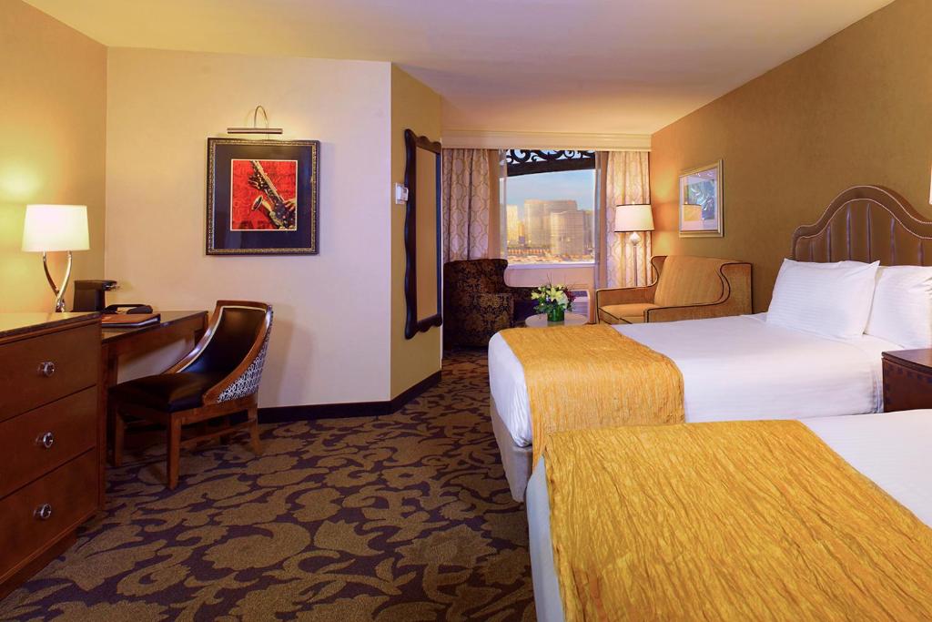 a hotel room with two beds and a desk at Comfy Unit at Orleans Casino Strip Las Vegas in Las Vegas