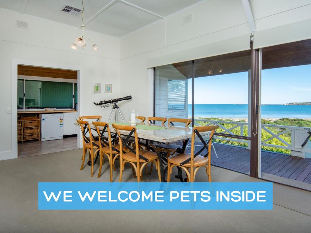 a dining room with a table and chairs with a view of the ocean at Absolute Beachfront 3BR 2BA Home w/ Beach Track in McCracken