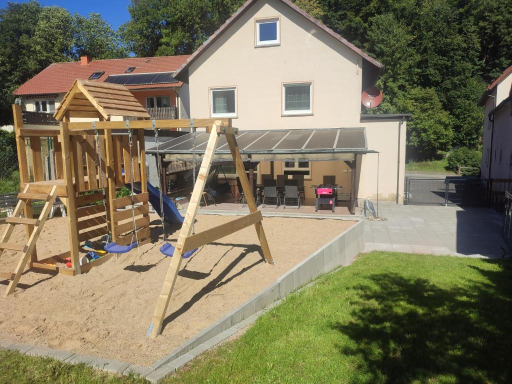 um parque infantil em frente a uma casa em Ferienhaus Seifert em Bischofsheim an der Rhön