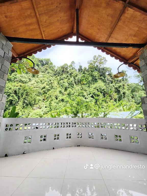 a stone wall withaques on it with trees in the background at Jungle Inn Bukit lawang in Bukit Lawang
