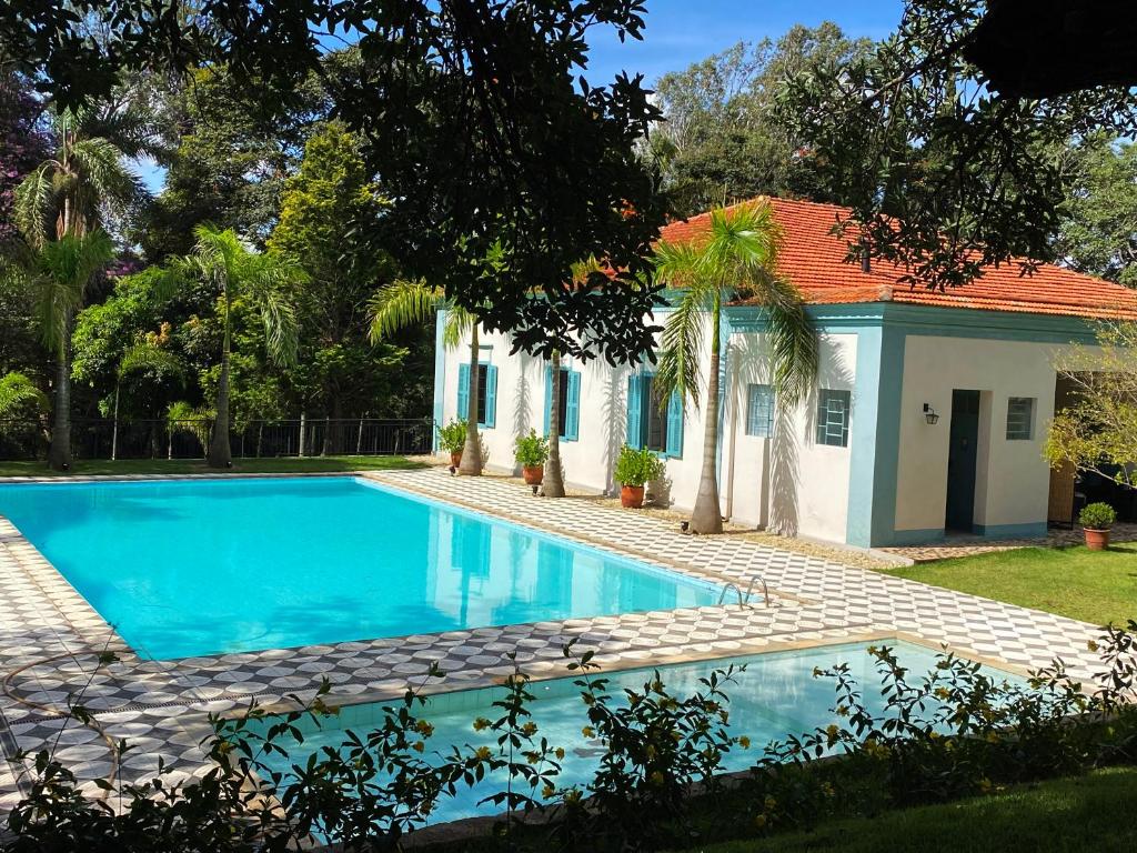 a swimming pool in front of a house at Limoeiro da Concórdia Hotel Fazenda de Charme in Itu