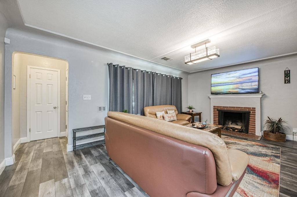 uma sala de estar com um sofá e uma lareira em Spacious & Quiet 4BR/2BA Home em Fresno