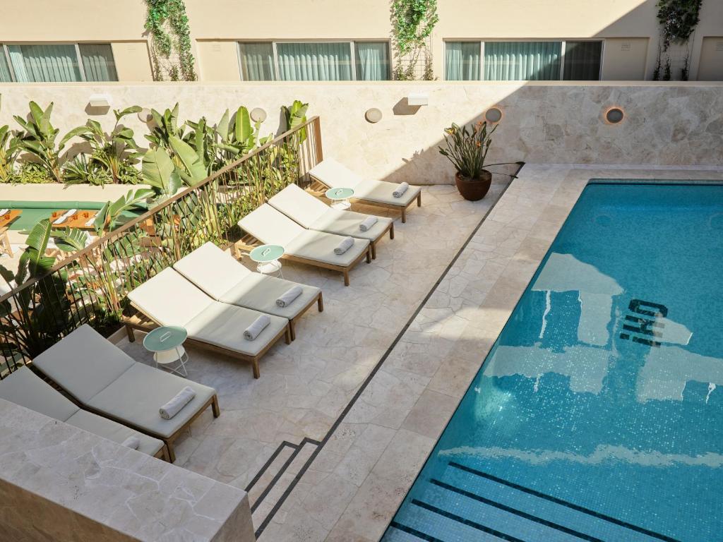 a row of lounge chairs next to a swimming pool at Oxford House in Sydney