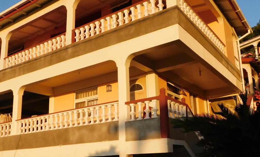 een geel huis met een balkon bij Sea View Guest Accommodation in Roseau