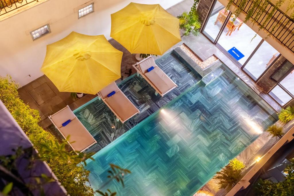 an overhead view of a pool with umbrellas and chairs at Tomorrow Boutique Villa Hoi An in Hoi An