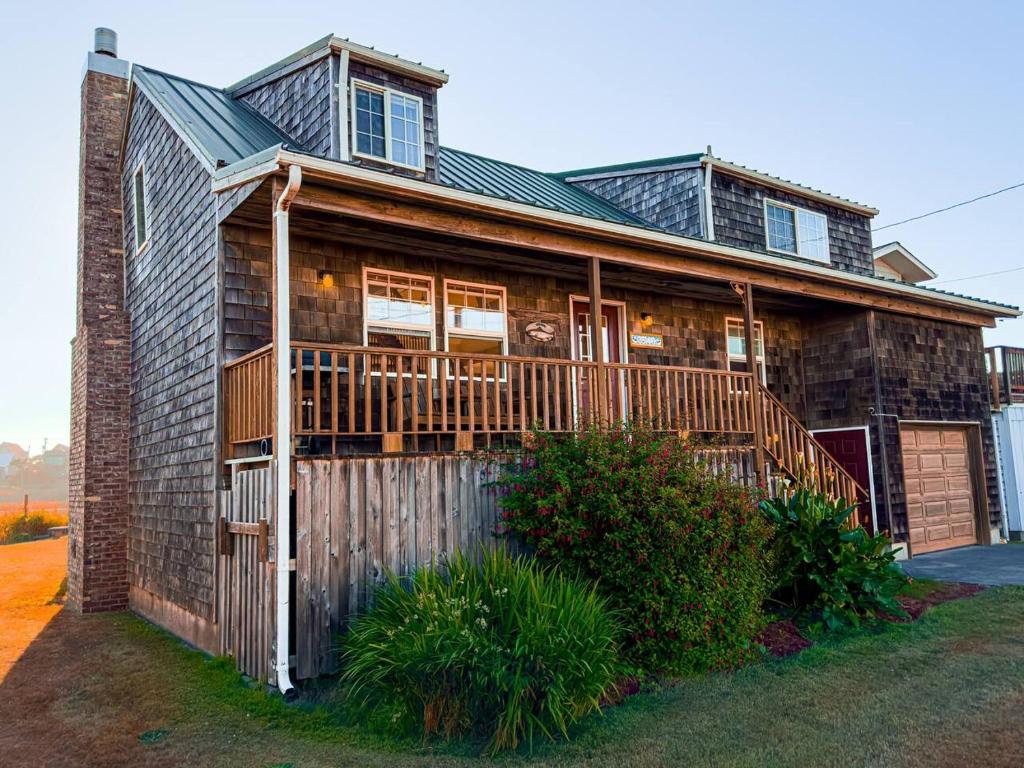 a large wooden house with a wooden deck at Pacific City River House Loft in Pacific City