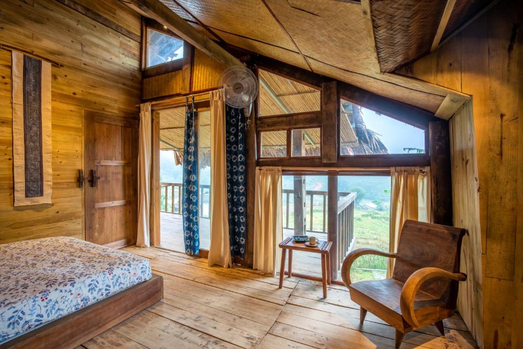una camera da letto con un letto, una sedia e una finestra di TALACÀ Homestay a Sa Pa