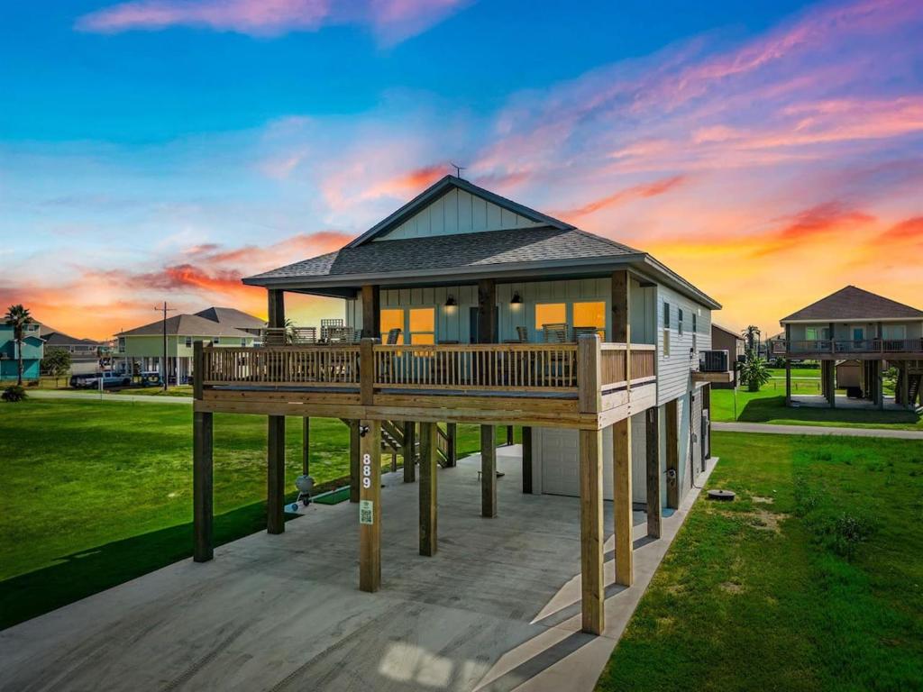 a house on a deck with a sunset in the background at The Breezy Turtle in Crystal Beach