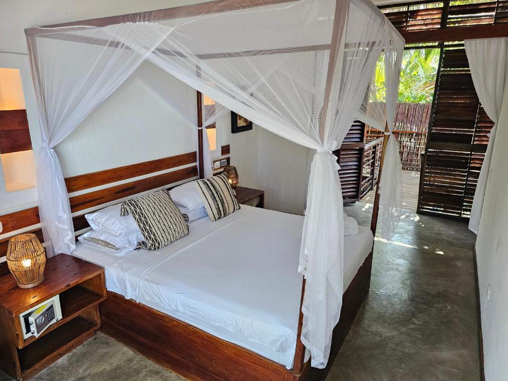 a bedroom with a bed with a canopy at Makao Beach Hotel in Palomino