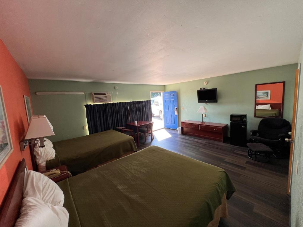 Cette chambre comprend deux lits et une télévision. dans l'établissement Town & Country Motel, à Sioux City
