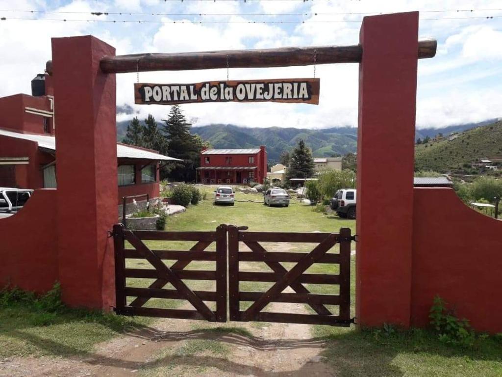 una puerta en la entrada de un complejo con un cartel en PORTAL DE LA OVEJERIA en Tafí del Valle