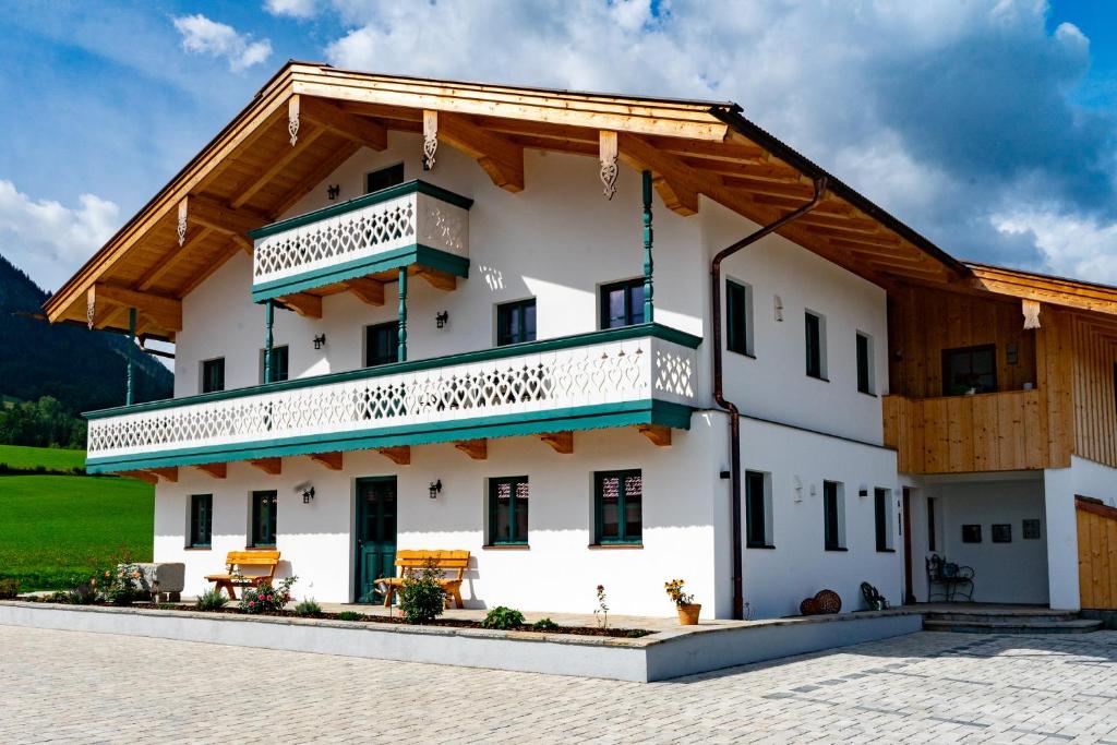 a large white building with a balcony at Ferienwohnungen Heillinger Gütl in Ruhpolding