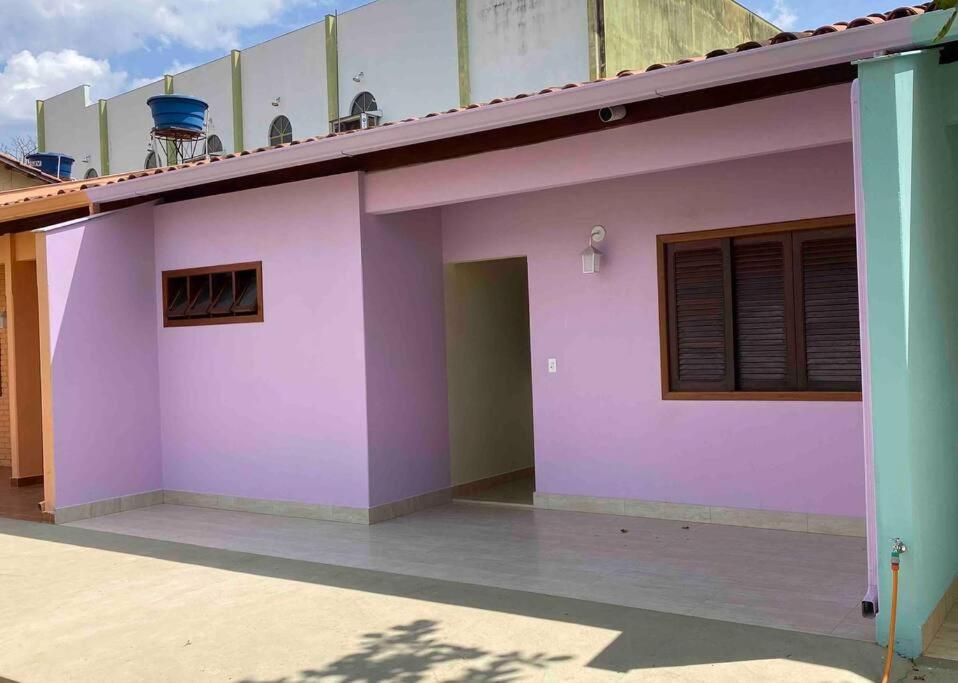 ein rosafarbenes und violettes Gebäude mit einem Balkon in der Unterkunft Casa 5 - Vila Francisco in Pirenópolis
