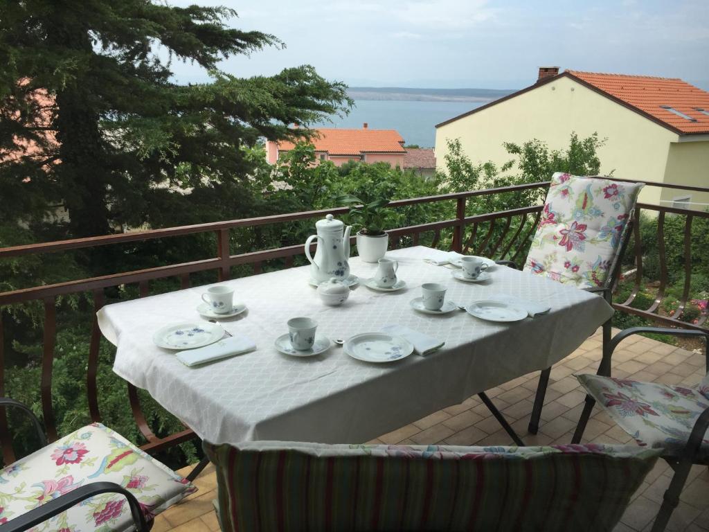 a table with cups and saucers on a balcony at Apartment Keka in Dramalj