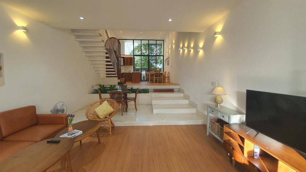 a living room with a couch and a tv at Holi Terrace Villa in Nha Trang