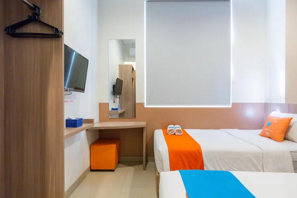 Postel nebo postele na pokoji v ubytování Sans Hotel Rajawali Surabaya by RedDoorz