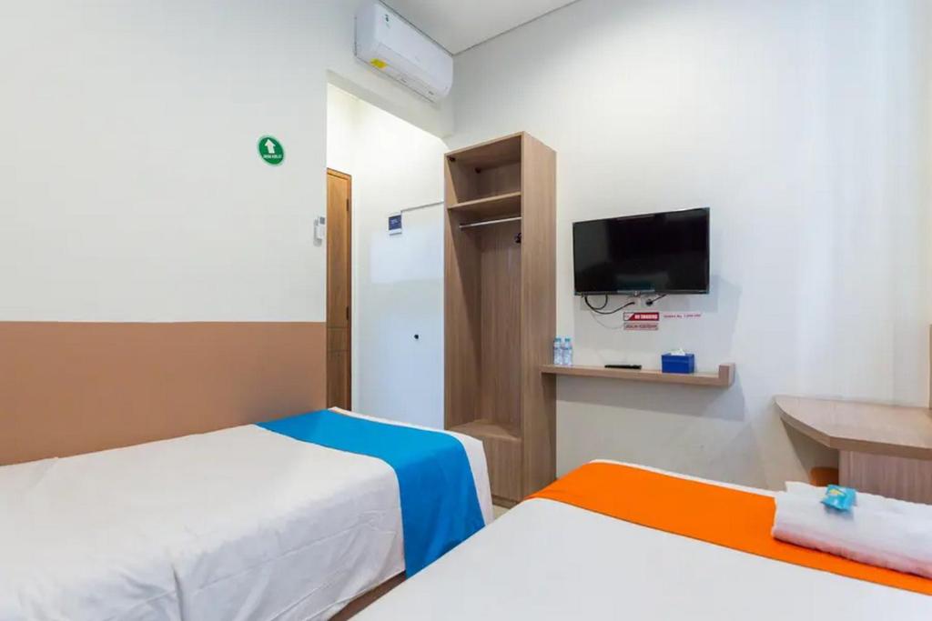 Postel nebo postele na pokoji v ubytování Sans Hotel Rajawali Surabaya by RedDoorz