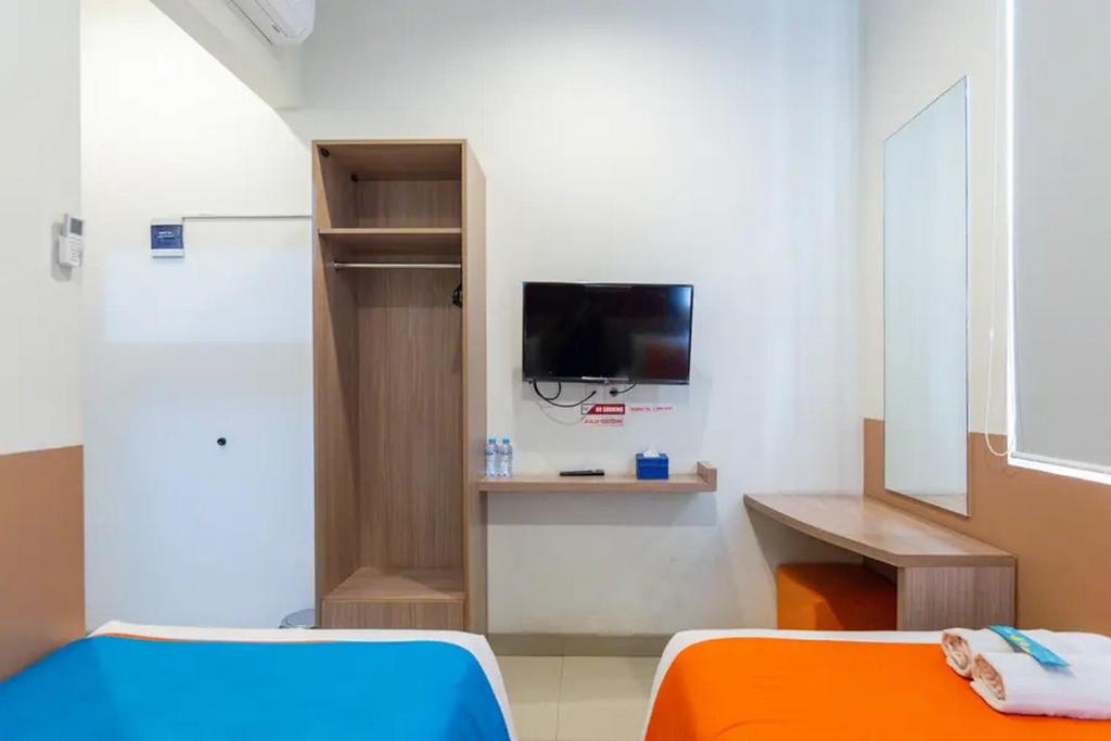 TV a/nebo společenská místnost v ubytování Sans Hotel Rajawali Surabaya by RedDoorz