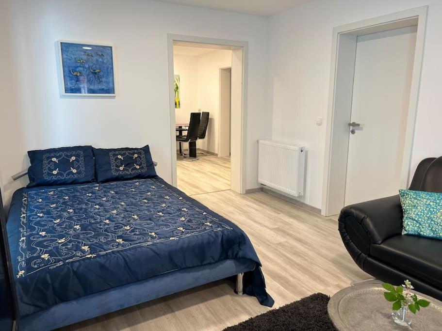 una camera con un letto blu e un divano di EG-Souterrain Wohnung a Marburg an der Lahn