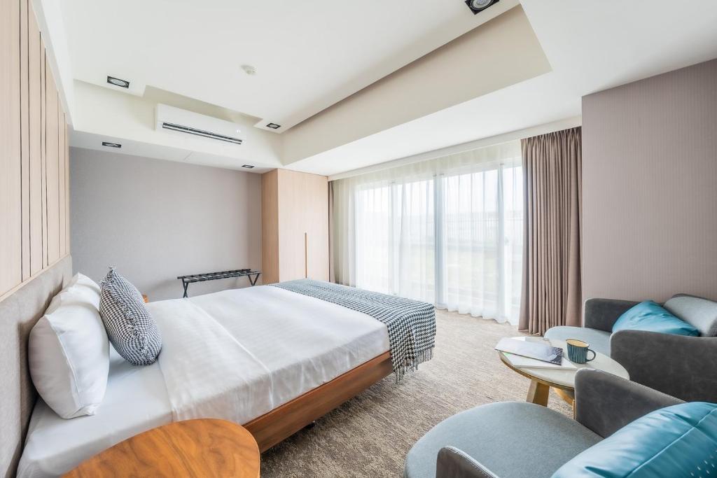 a hotel room with a bed and a couch at TH Hotel in Pingtung City