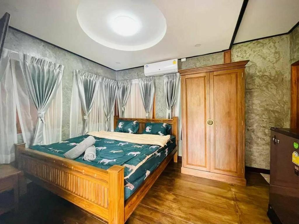 1 dormitorio con 1 cama con marco de madera en Pup Resort River View (ปั๊บ รีสอร์ท), en Mae Taeng