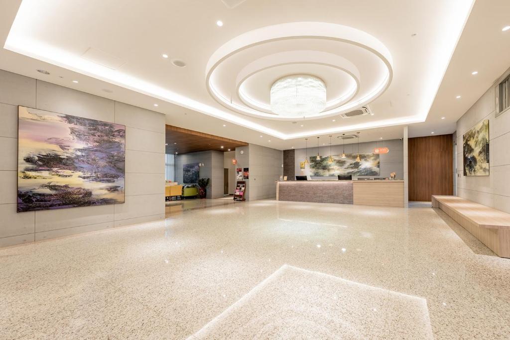 a large lobby with a ceiling with a large room at TH Hotel in Pingtung City