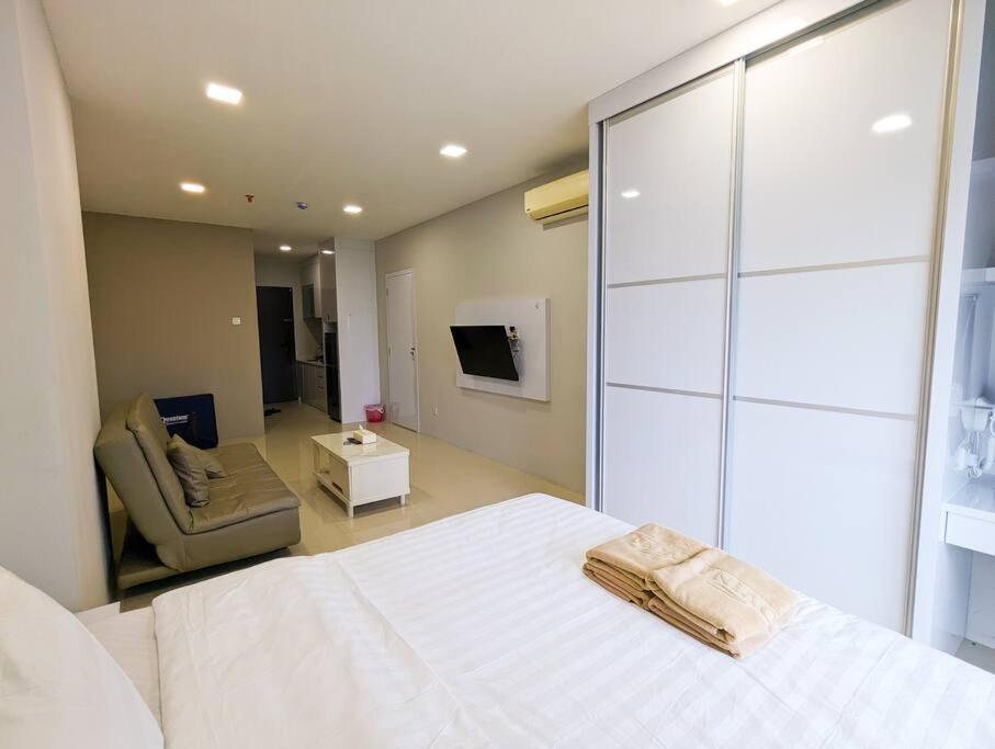 una camera con un letto bianco e una sedia di Lovina 20-12B Formosa Residence a Nagoya