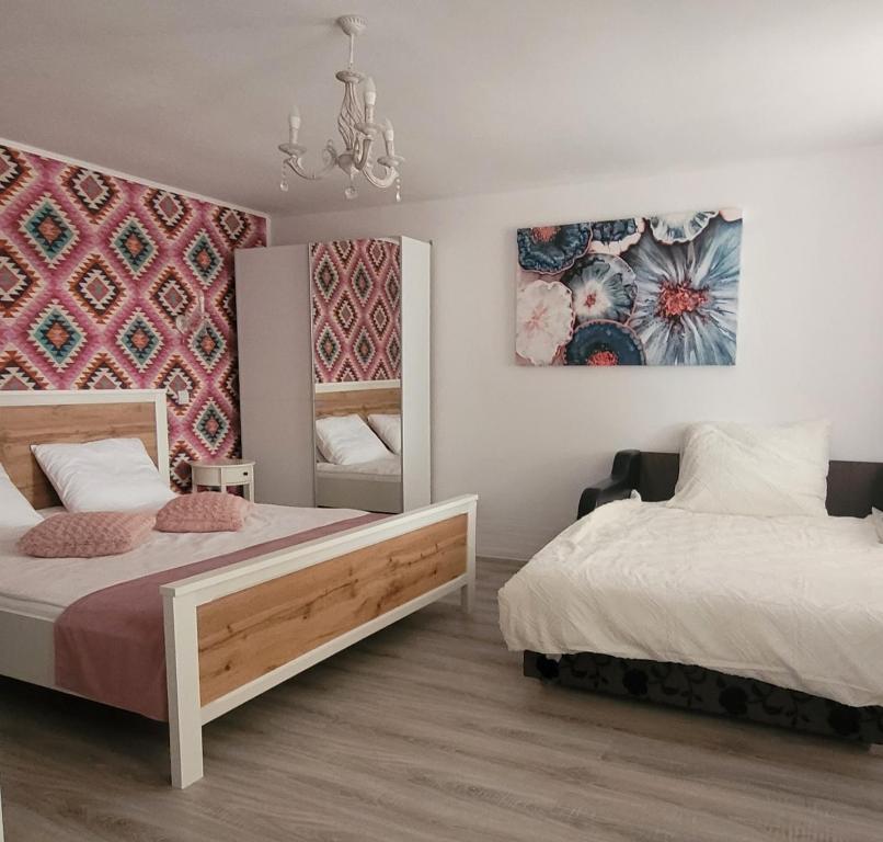 a bedroom with two beds and a mirror at Casa Domnească in Giurgiu
