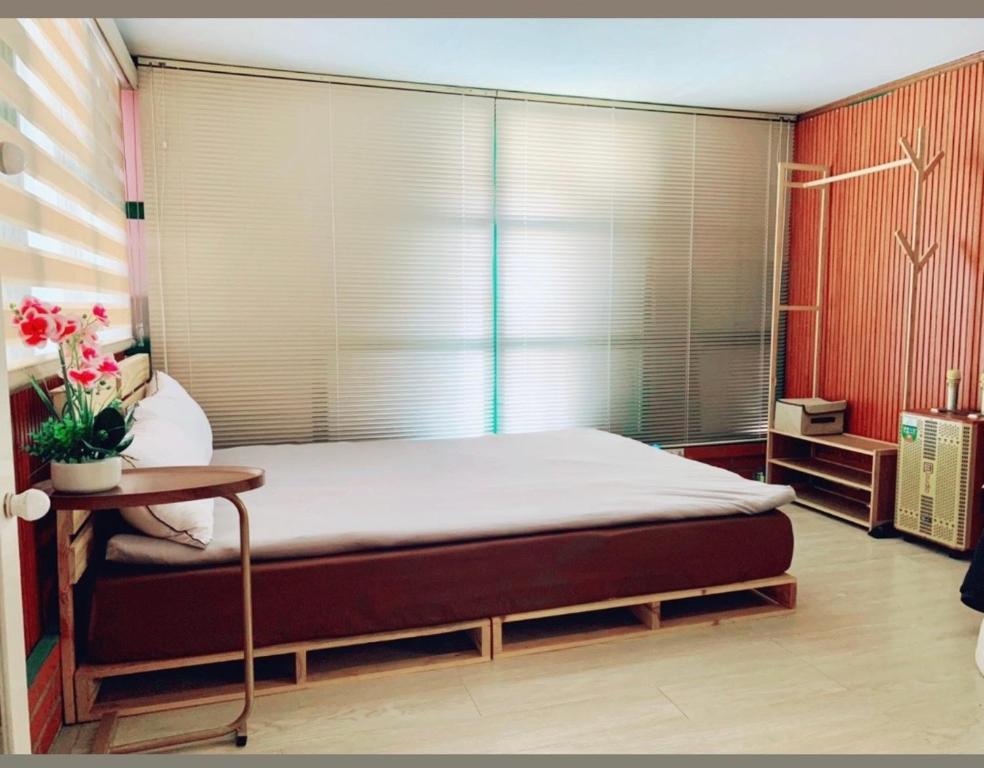 ein Schlafzimmer mit einem großen Bett und einem Fenster in der Unterkunft Old House Homestay in Hanoi
