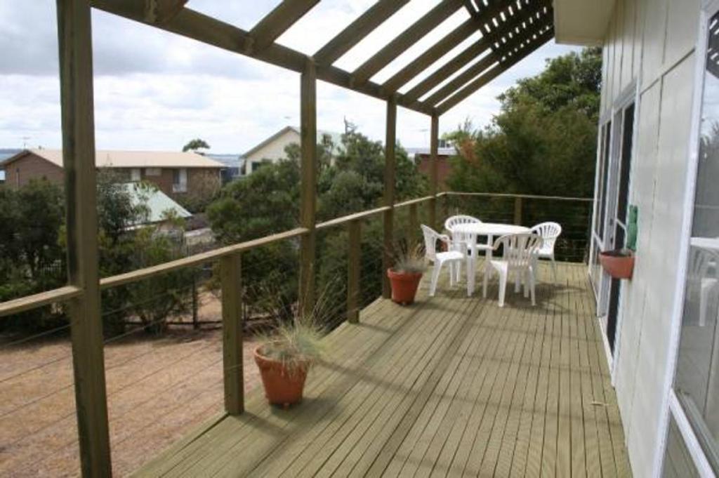 a patio with a table and chairs on a deck at Salt On Seacombe in Ventnor