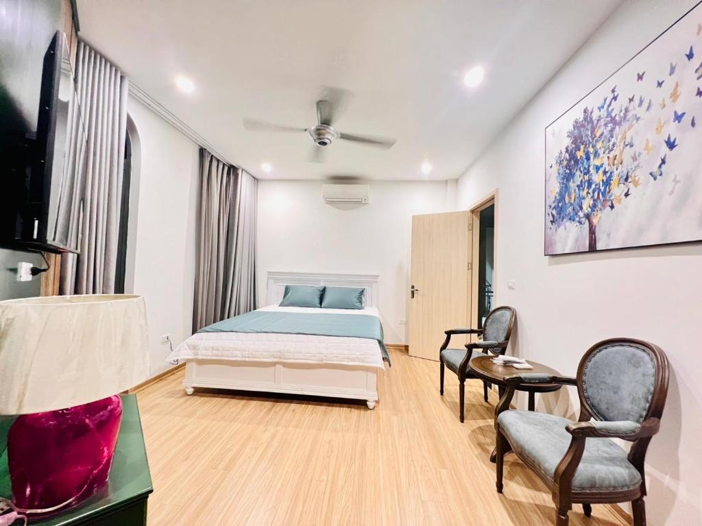 1 dormitorio con 1 cama y 2 sillas en Hungchu Villa, en Gia Lâm Pho