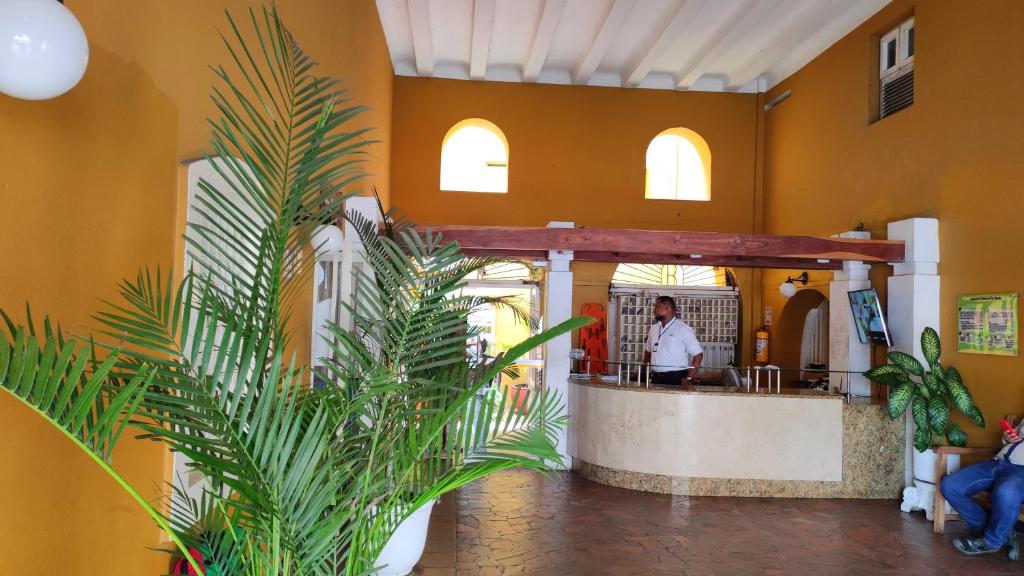 a lobby with a counter and a man in a kitchen at Happy tours apartments in Cartagena de Indias