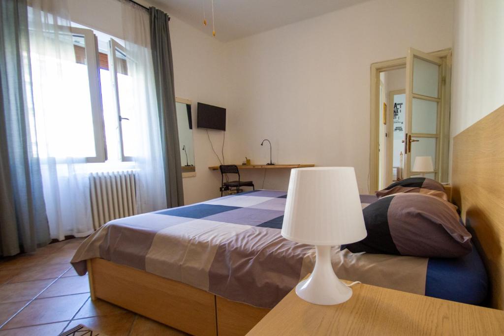 una camera da letto con un letto e una lampada su un tavolo di LA DIMORA DEGLI ELFI casa vacanza a Pavia