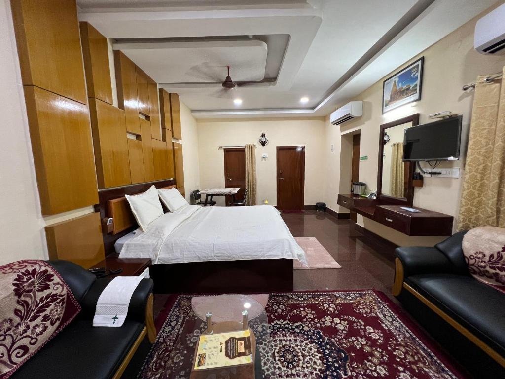 a hotel room with a bed and a couch at Hotel TamilNadu - Thanjavur in Thanjāvūr