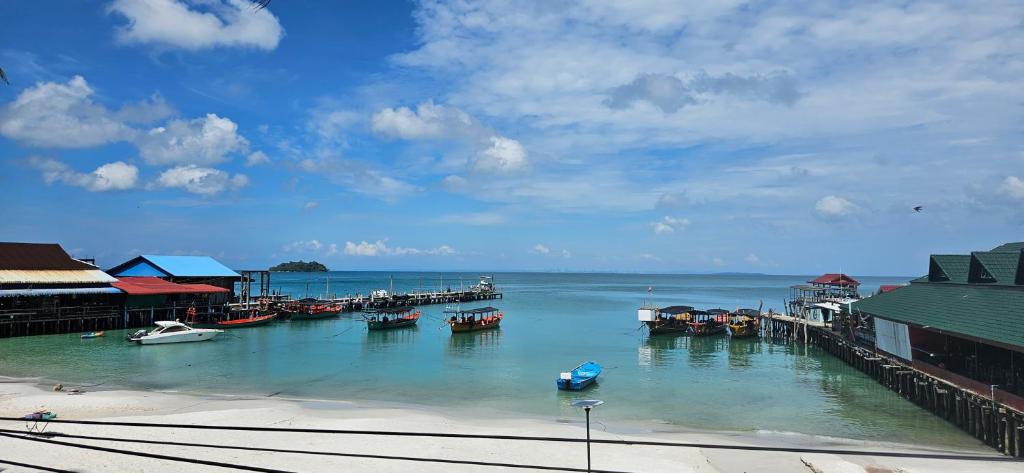 a group of boats docked at a dock in the water at Lucky Leprechaun in Koh Rong Island