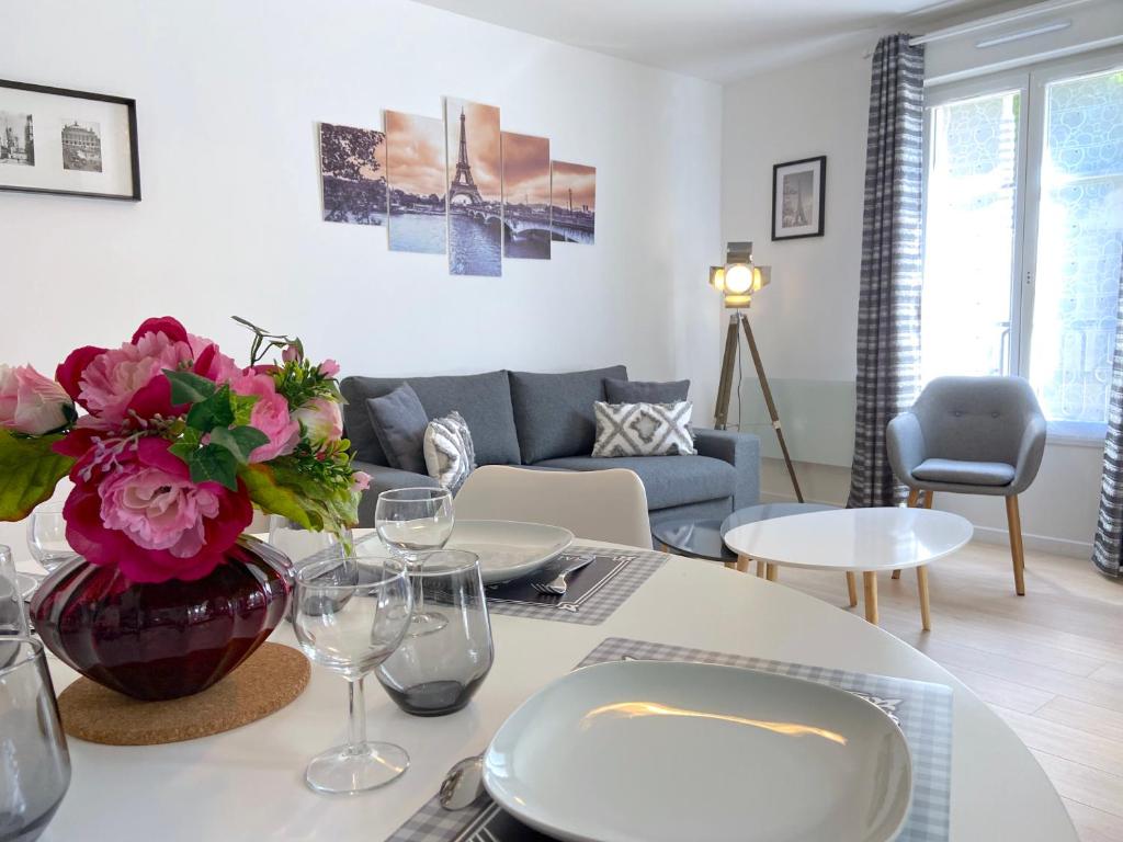 a living room with a table with a vase of flowers at Casaminnie - Appartement à 8 min de Disneyland Paris in Bussy-Saint-Georges