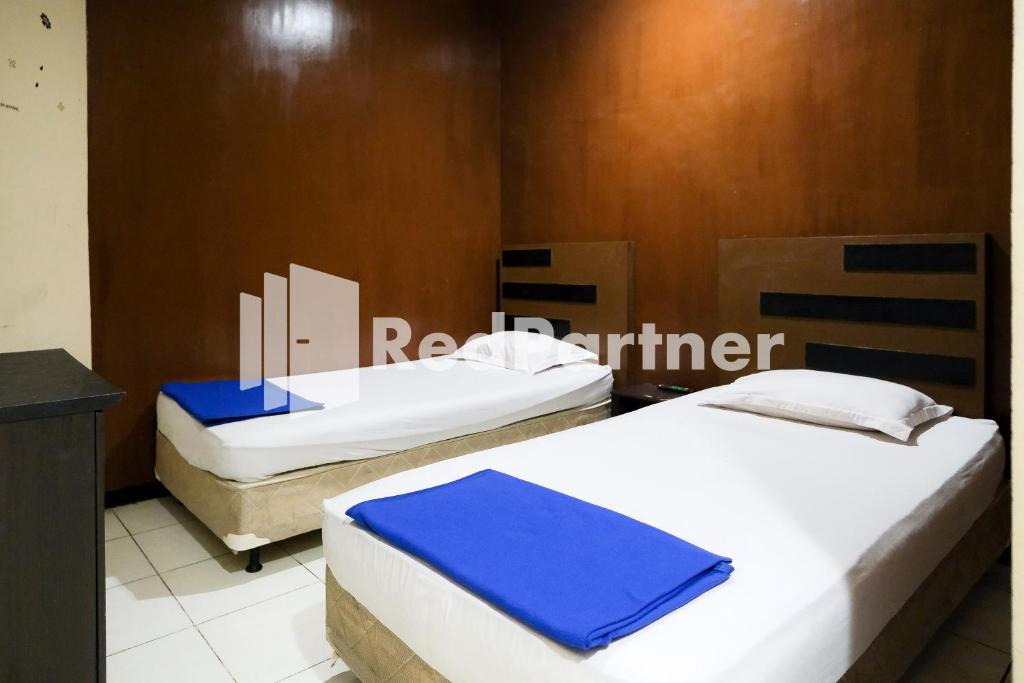 Habitación con 2 camas en una habitación en RedDoorz at Sparkling Hotel Surabaya, en Surabaya
