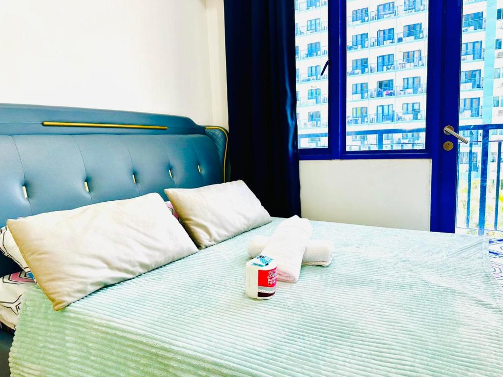 Una cama con una taza de café. en Sea Residences Apartment by Kevin Alano, en Manila