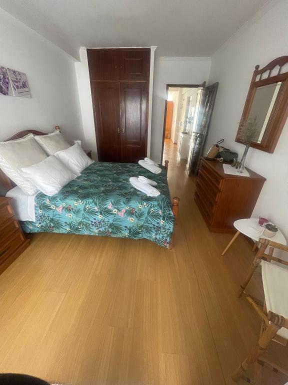 1 dormitorio con 1 cama y suelo de madera en Spacieux Appartement à Porto en bord mer, en Póvoa de Varzim
