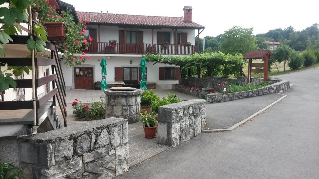 uma casa com uma parede de pedra ao lado de uma rua em Homestead Vrbin em Divača