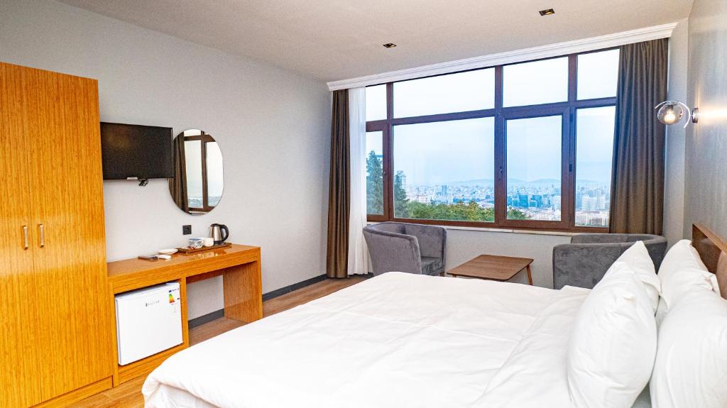 een hotelkamer met een bed en een groot raam bij ELİTE MARMARA BOSPHORUS & OTEL in Istanbul