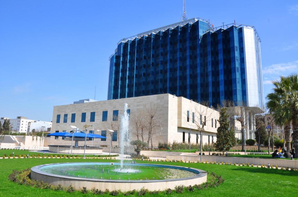 a fountain in a park in front of a building at Erbil International Hotel in Erbil