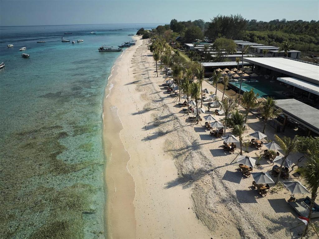 an overhead view of a beach with chairs and umbrellas at BASK Gili Meno in Gili Meno