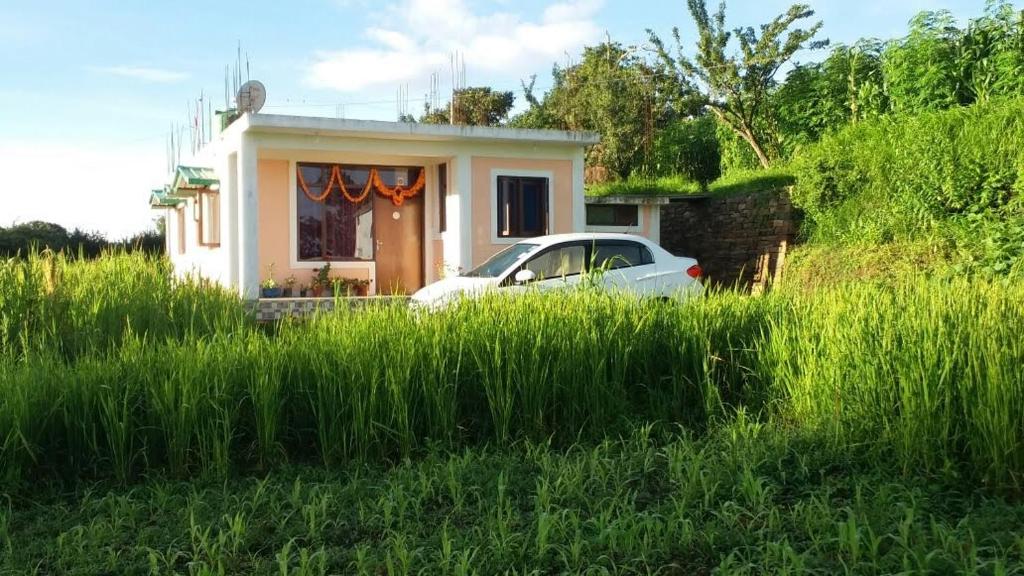 a white car parked in front of a small house at Vamoose - Yog Homestay in Chaubattia